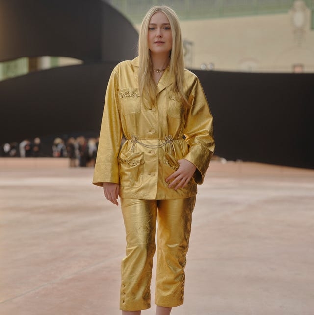 a person wearing a golden outfit and high heels poses in a fashion setting